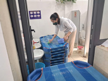 Giáo viên giặt giường ngủ cho trẻ sau khi phun thuốc diệt muỗi , côn trùng
